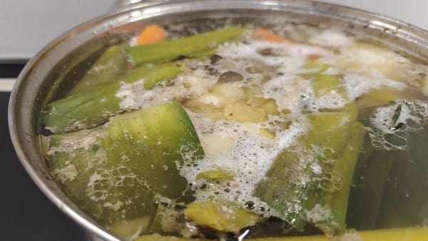 Homemade beef soup gently simmering with leek and vegetables