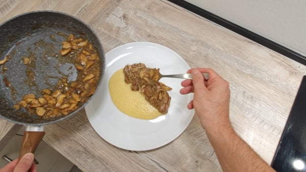Serving of creamy Parmesan polenta topped with porcini mushrooms.